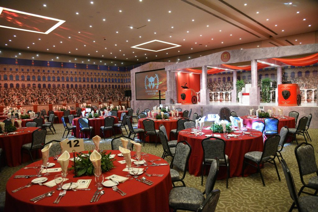 Luxurious setup for a Roman-themed event with red table settings, ideal for formal dinners or parties.